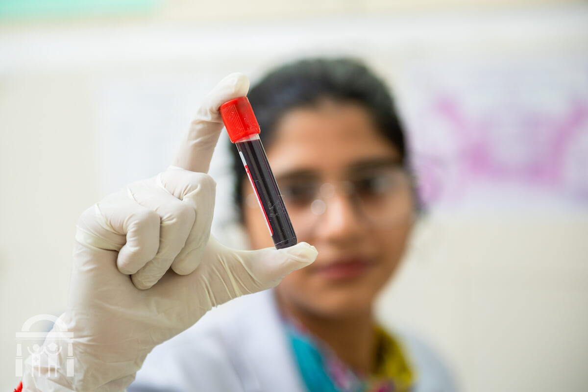 Blood sample vial being held up close by lab technician at Guru Nanak Mission Hospital Dhahan Kaleran near Banga